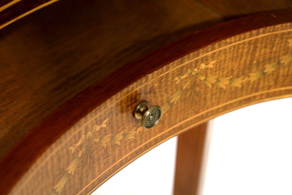 A late Victorian kidney-shaped mahogany side table featuring decorative floral marquetry inlay, slender tapered legs, a small apron drawer, and a lower tier shelf. View VI