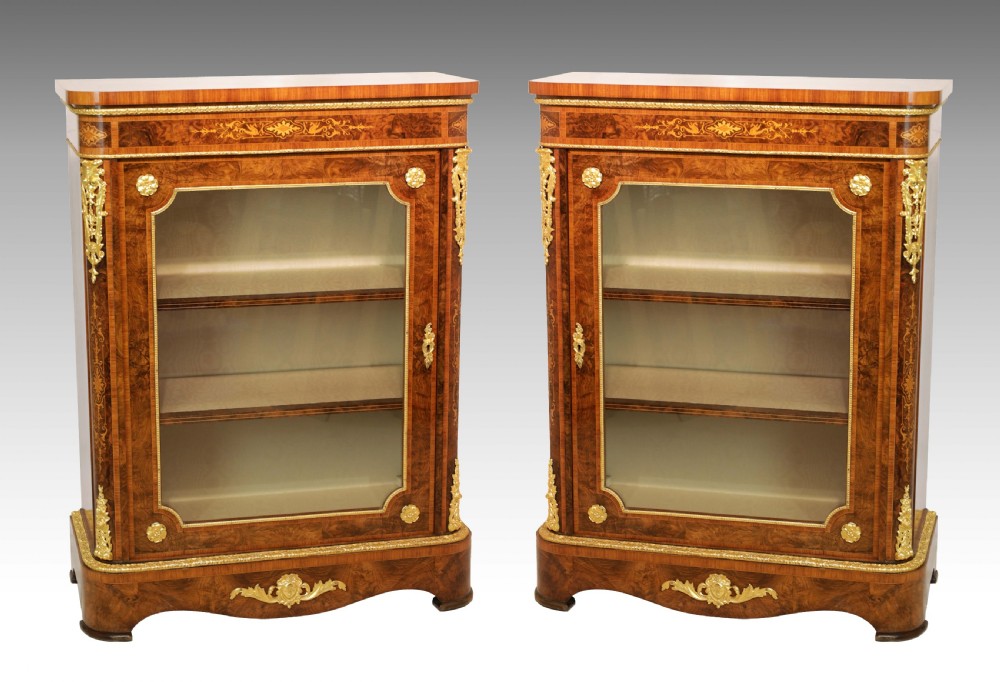 A pair of late nineteenth-century glazed display cabinets crafted from kingwood and walnut with decorative gilt-bronze mounts.