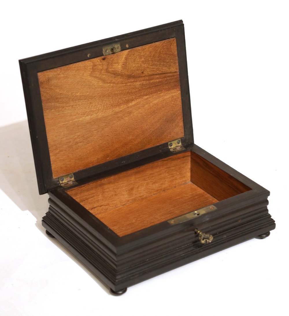 A 19th-century rectangular ebonised wood box featuring a pietra dura floral inlay of a white iris and red poppy on the lid, resting on small bun feet. View II
