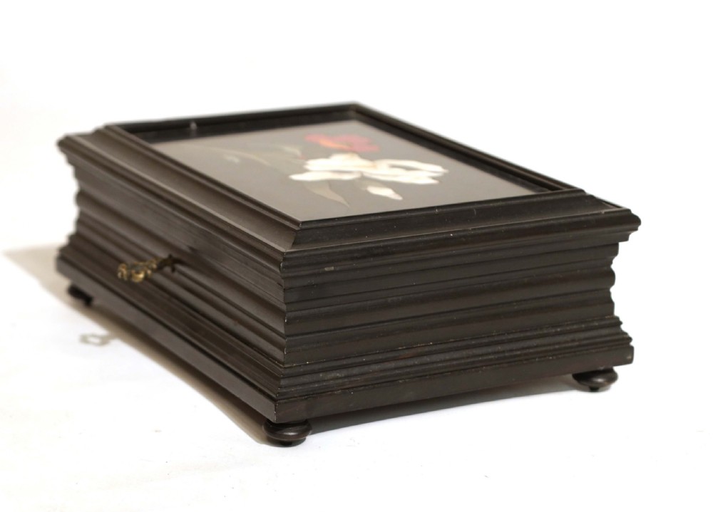 A 19th-century rectangular ebonised wood box featuring a pietra dura floral inlay of a white iris and red poppy on the lid, resting on small bun feet. View III