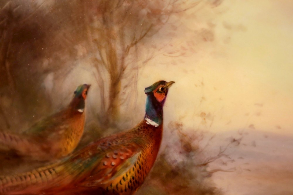 An oval-framed porcelain plaque featuring a hand-painted scene of two pheasants in a misty landscape, enclosed in a gold ornate frame. View IV