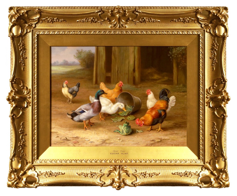 A framed oil painting depicting chickens, a cockerel, and ducks feeding outside a wooden barn, set within an ornate gilded frame.