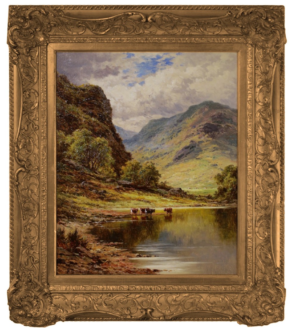 A Victorian oil painting depicting cattle watering at a mountain lake, housed within a deeply carved giltwood frame.