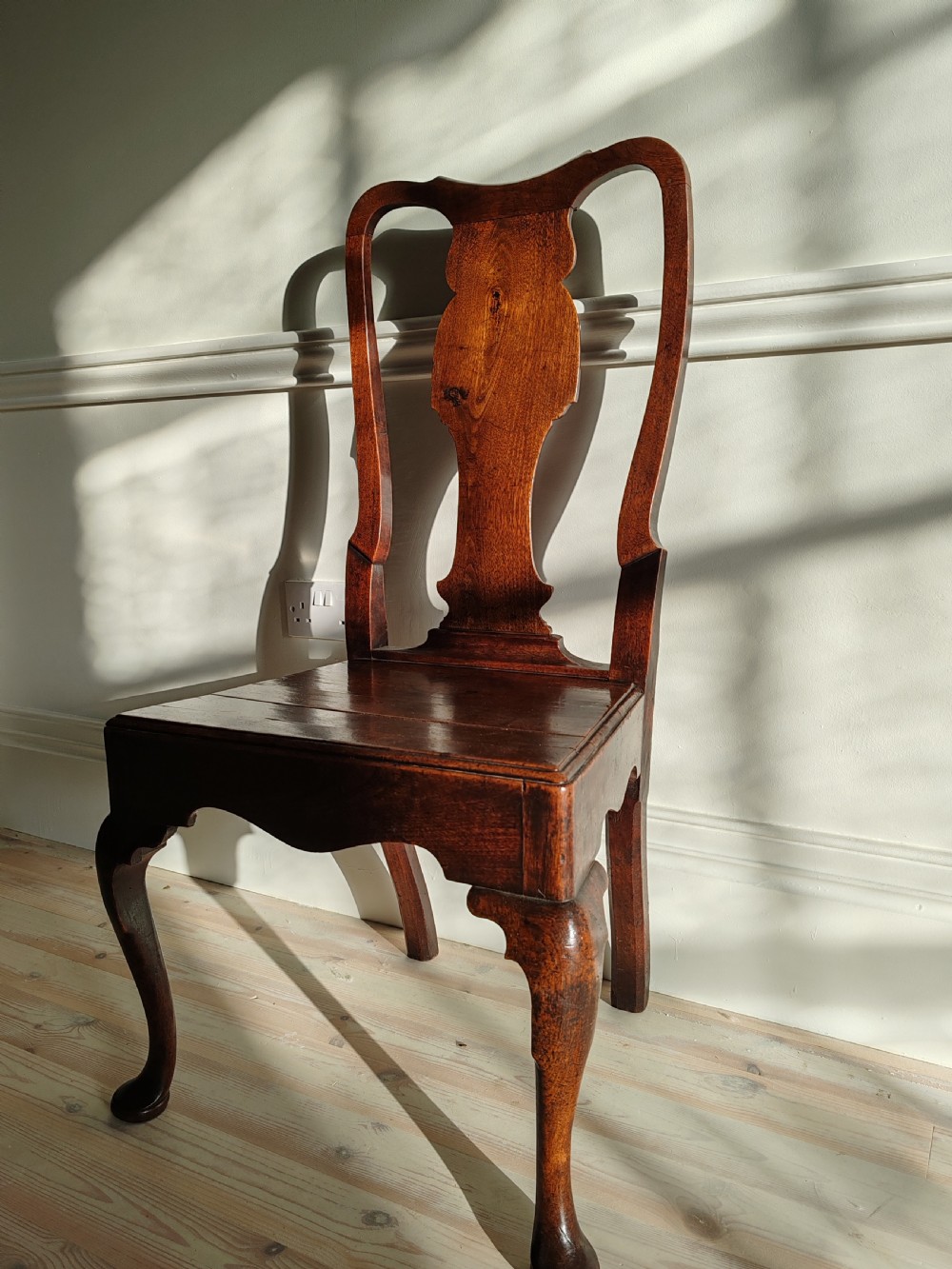 A mid-18th-century walnut side chair with a vase-shaped back splat, solid wooden seat, and front cabriole legs. View V