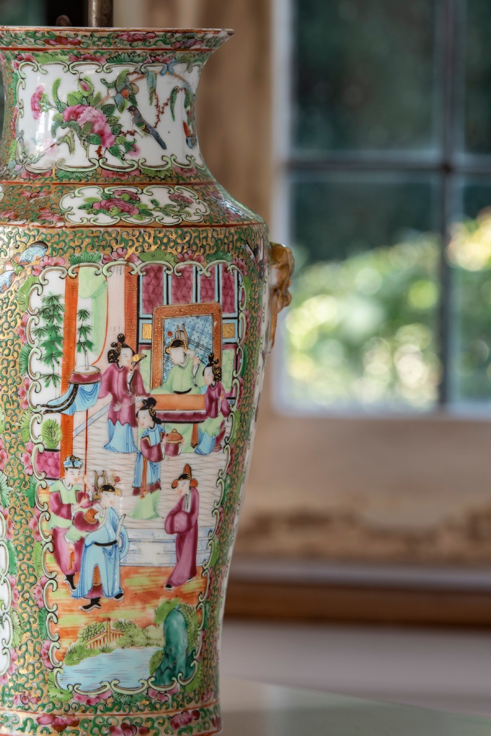 A pair of large Chinese Canton porcelain vase lamps with hand-painted polychrome figural panels, floral borders, and brass light fittings. View V
