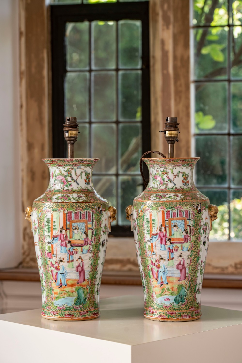 A pair of large Chinese Canton porcelain vase lamps with hand-painted polychrome figural panels, floral borders, and brass light fittings. View VI