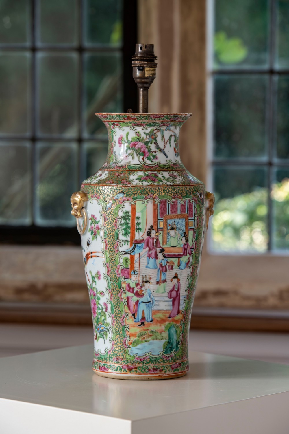 A pair of large Chinese Canton porcelain vase lamps with hand-painted polychrome figural panels, floral borders, and brass light fittings. View X