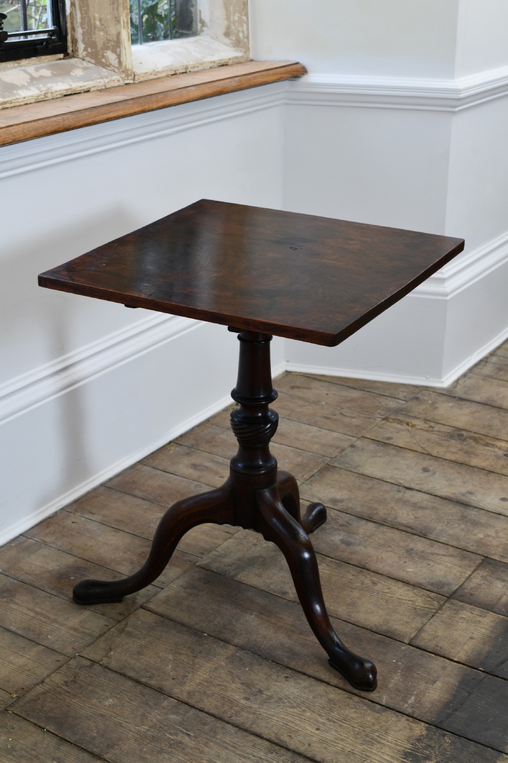An 18th-century dark mahogany tripod table featuring a square top supported by a turned stem with a spiral baluster detail and three cabriole legs ending in pad feet.