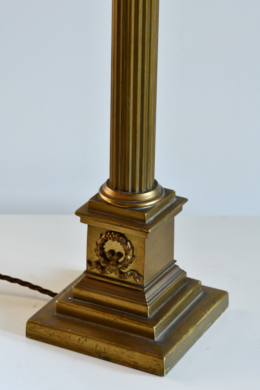 A late nineteenth-century brass table lamp featuring a fluted Corinthian column on a square stepped pedestal base. View V
