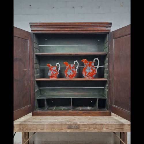 A late 18th-century Georgian oak wall cabinet featuring twin fielded panel doors, brass knobs, an escutcheon, and a moulded top cornice. View VI