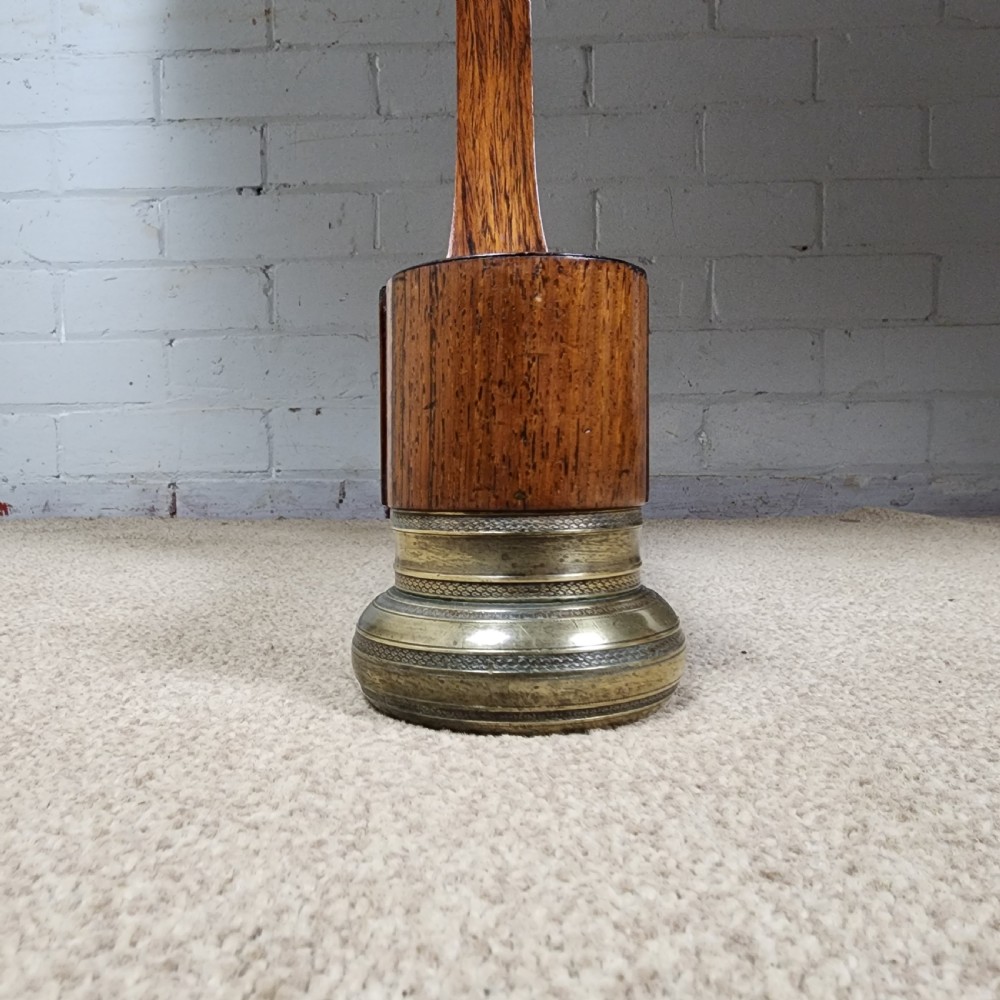 An early 19th-century Regency period rosewood sofa table featuring drop-leaf ends, twin trestle supports, decorative brass mounts, and brass castors. View VI