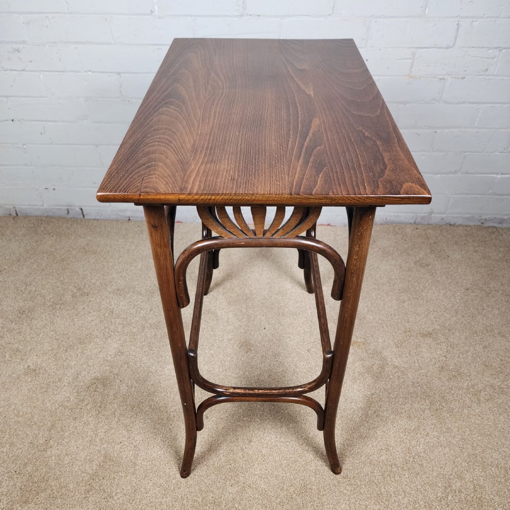 An Art Nouveau dark brown bentwood side table featuring carved palmette apron details and curved leg supports. View V