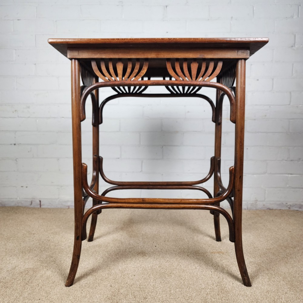 An Art Nouveau dark brown bentwood side table featuring carved palmette apron details and curved leg supports. View VIII