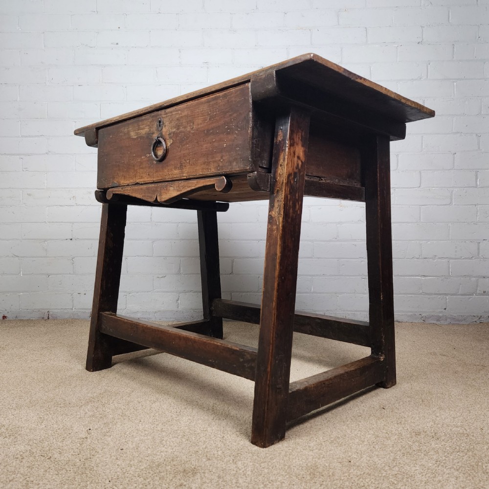 A 17th-century Spanish chestnut side table with a single drawer featuring a central wrought iron ring pull and a box stretcher base. View II