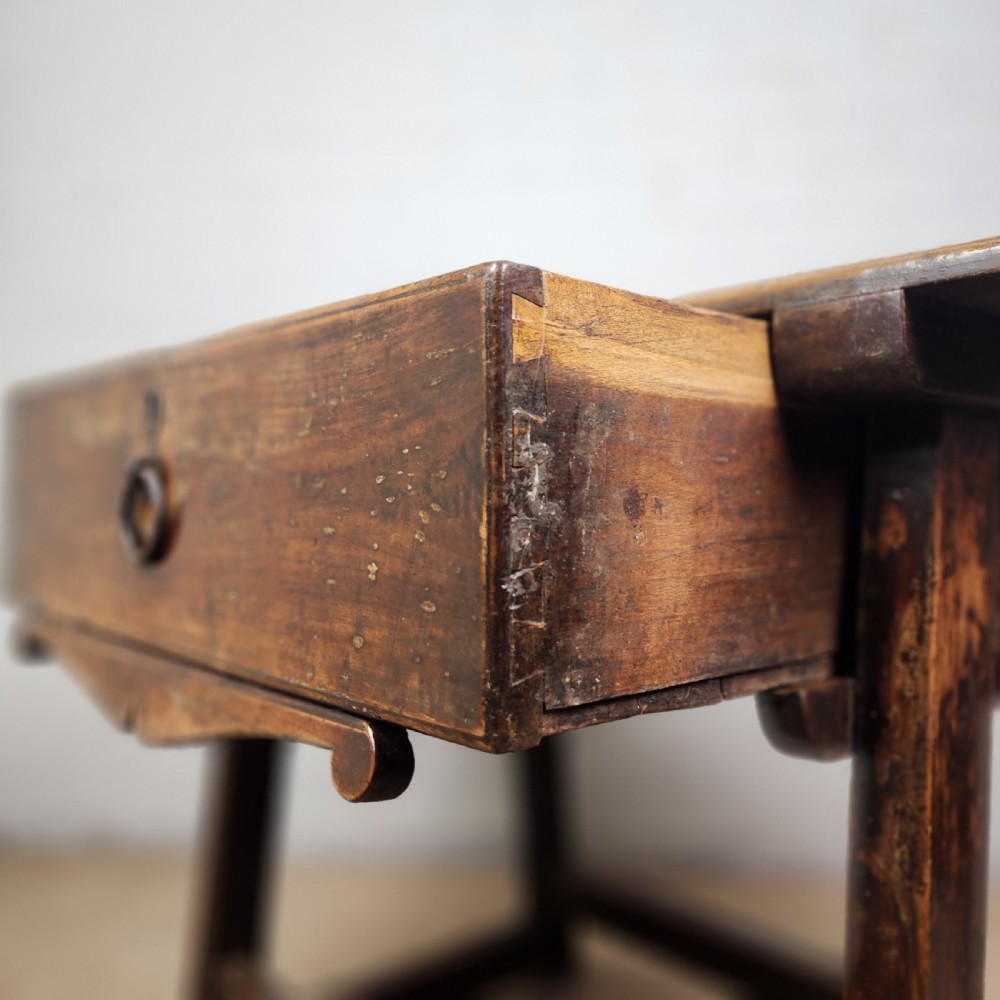 A 17th-century Spanish chestnut side table with a single drawer featuring a central wrought iron ring pull and a box stretcher base. View V
