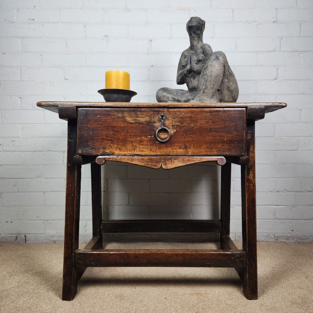 A 17th-century Spanish chestnut side table with a single drawer featuring a central wrought iron ring pull and a box stretcher base.