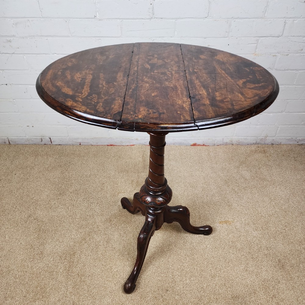 A Victorian circular occasional table made from dark burr walnut and mahogany, featuring drop leaves, a swivel top, a spiral carved central stem, and tripod carved feet. View XIII