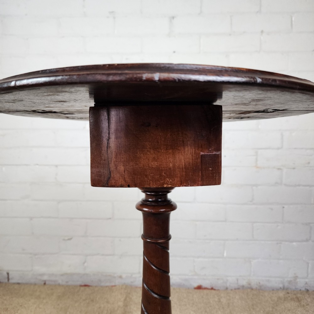 A Victorian circular occasional table made from dark burr walnut and mahogany, featuring drop leaves, a swivel top, a spiral carved central stem, and tripod carved feet. View VIII