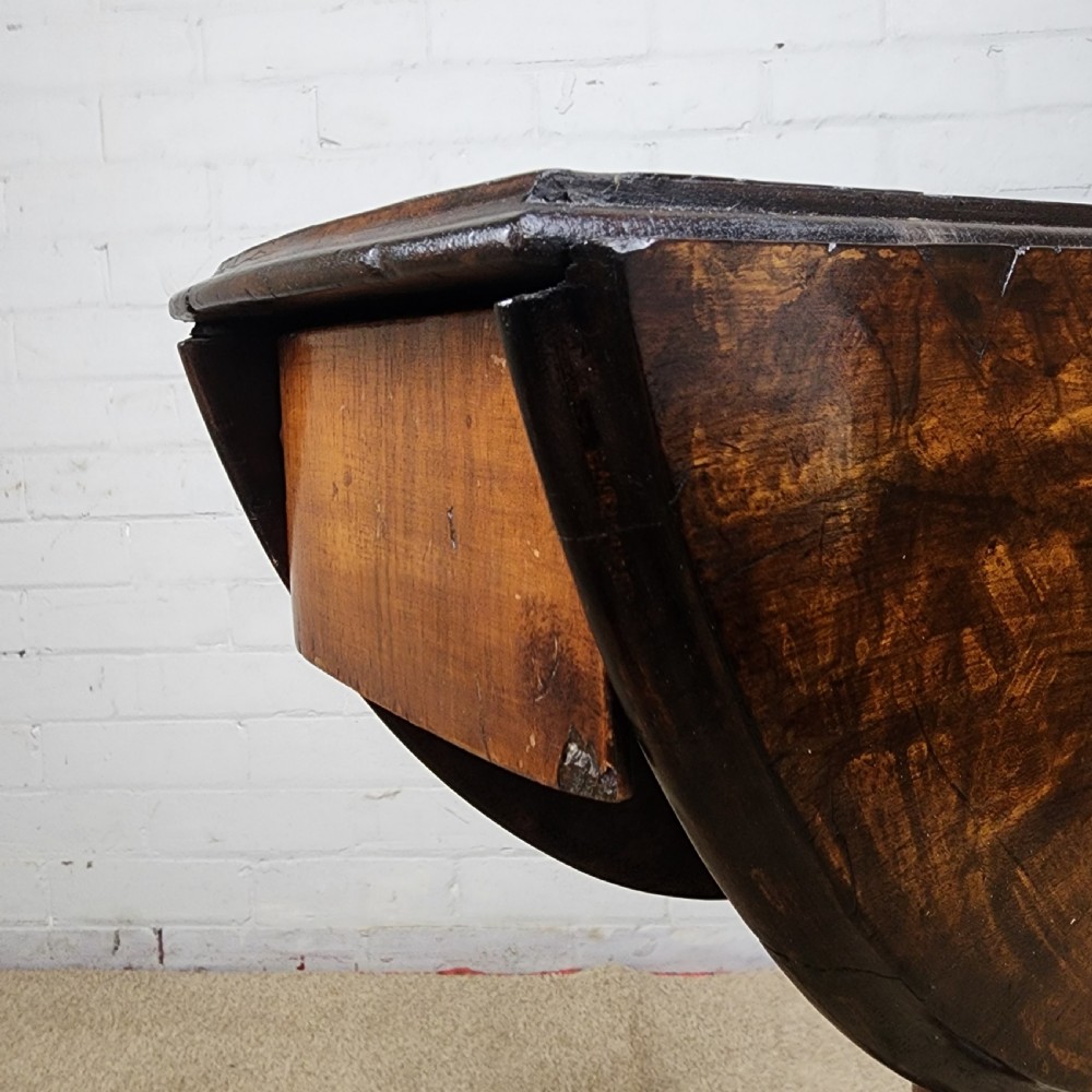 A Victorian circular occasional table made from dark burr walnut and mahogany, featuring drop leaves, a swivel top, a spiral carved central stem, and tripod carved feet. View XII