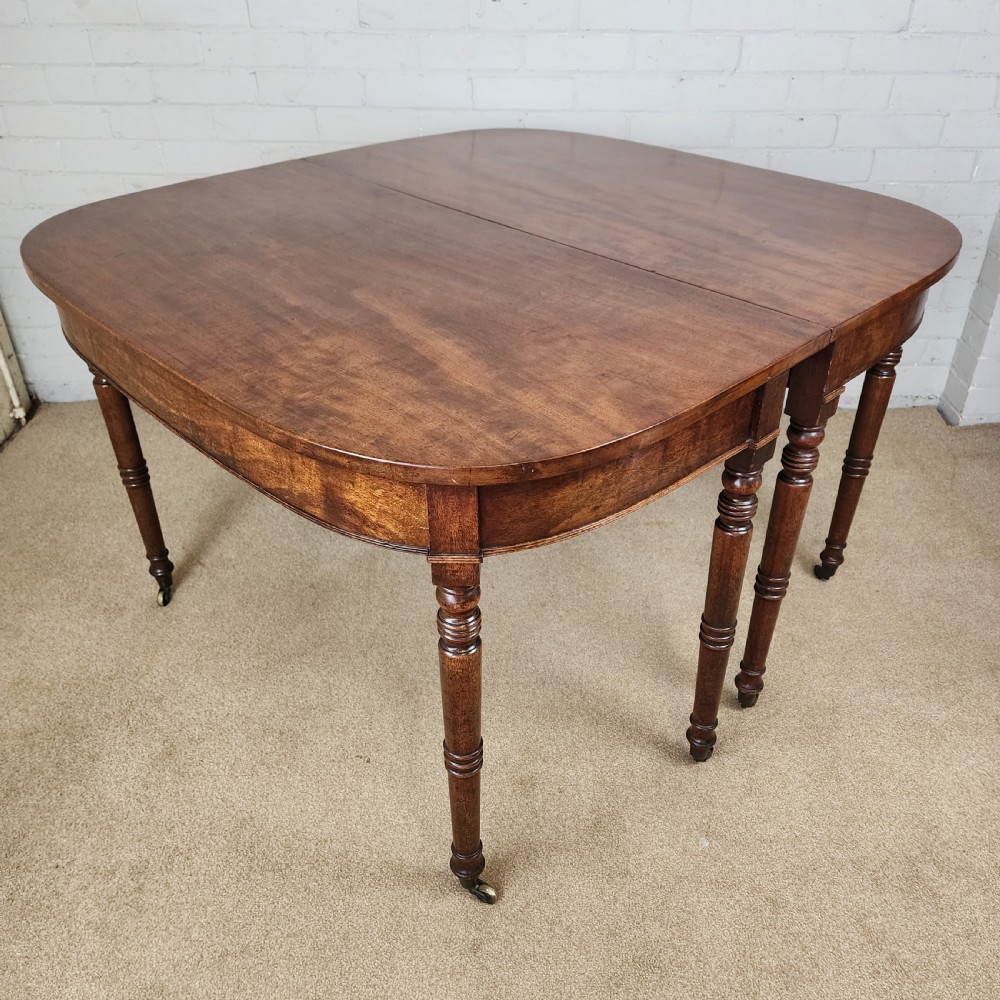 A George IV mahogany extending dining table featuring rounded D-ends, a polished timber surface, and turned legs. View III