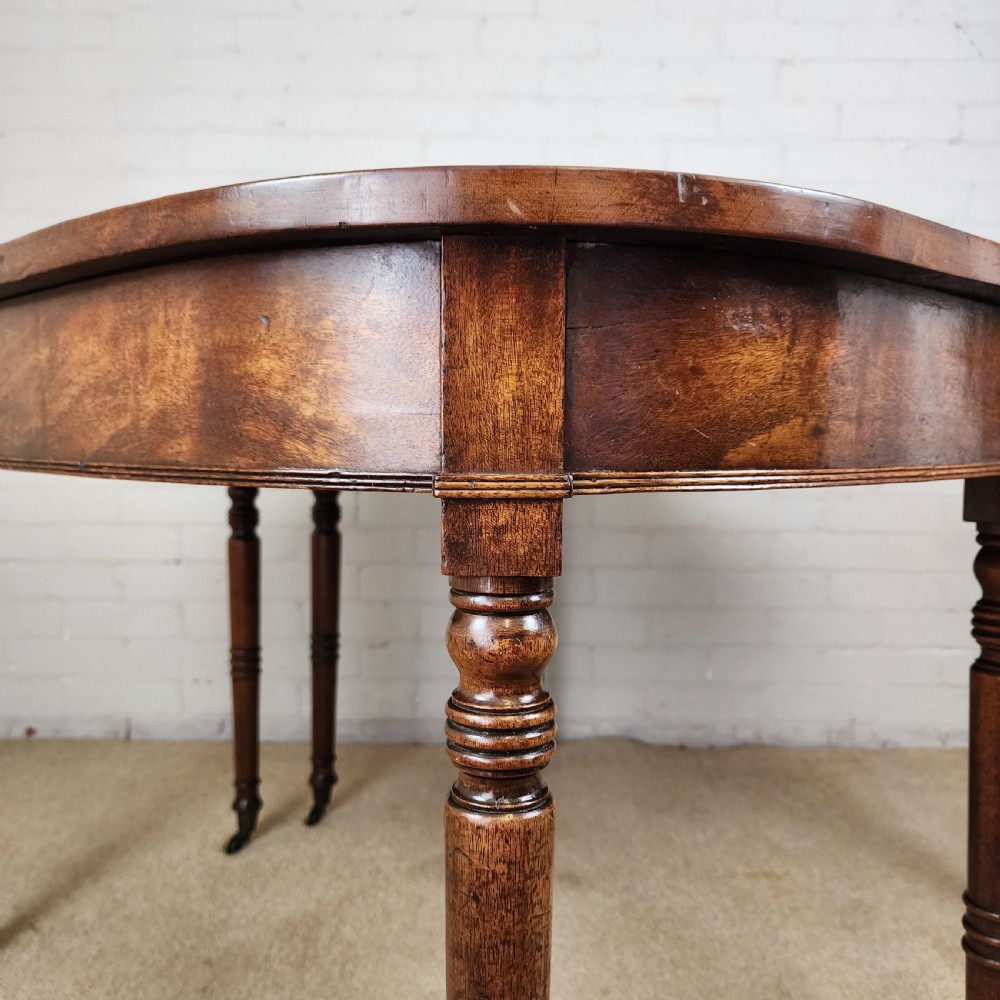 A George IV mahogany extending dining table featuring rounded D-ends, a polished timber surface, and turned legs. View V