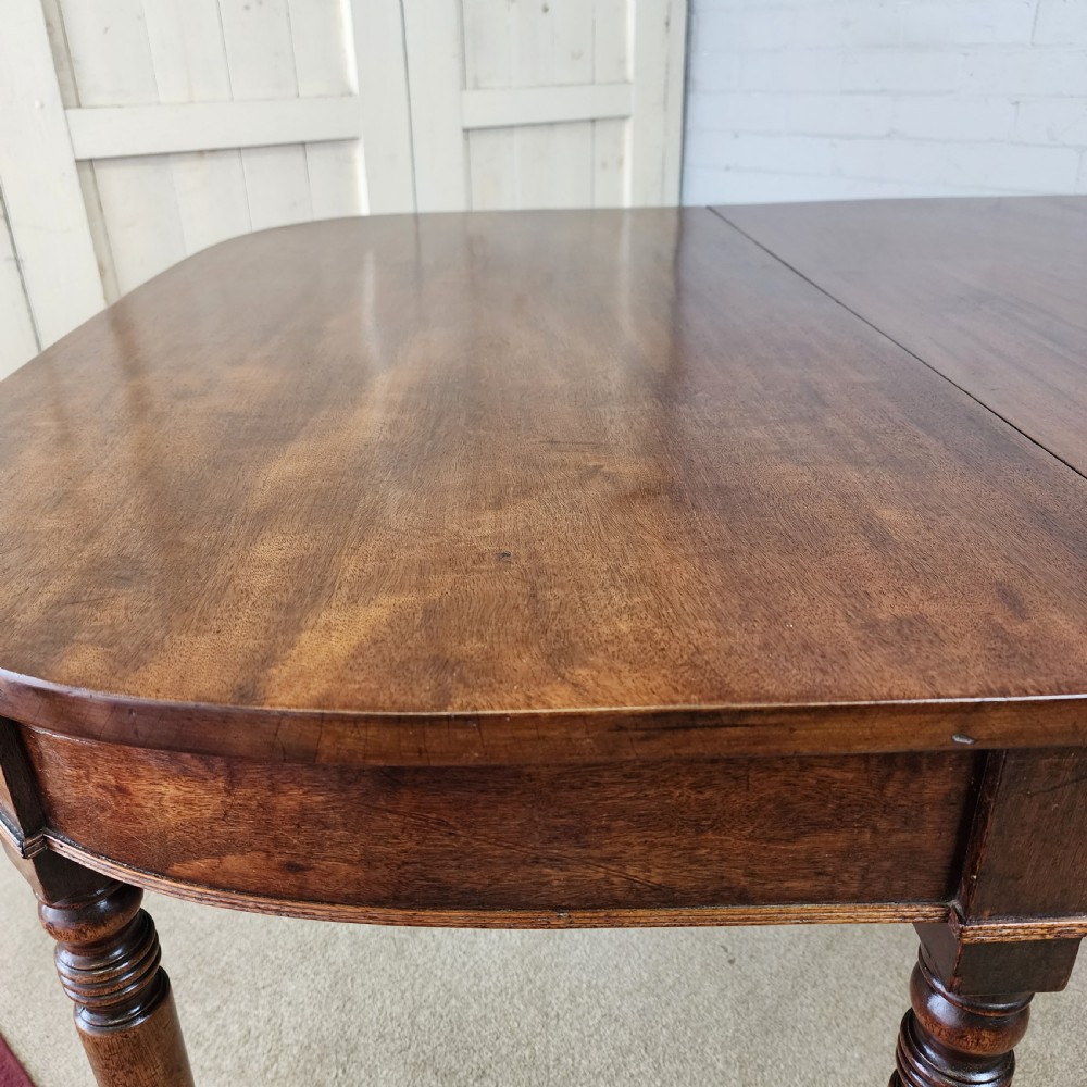 A George IV mahogany extending dining table featuring rounded D-ends, a polished timber surface, and turned legs. View VIII