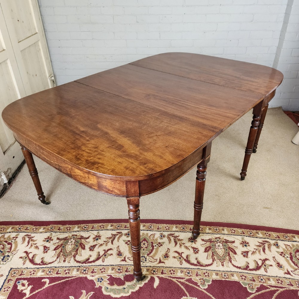 A George IV mahogany extending dining table featuring rounded D-ends, a polished timber surface, and turned legs. View IX