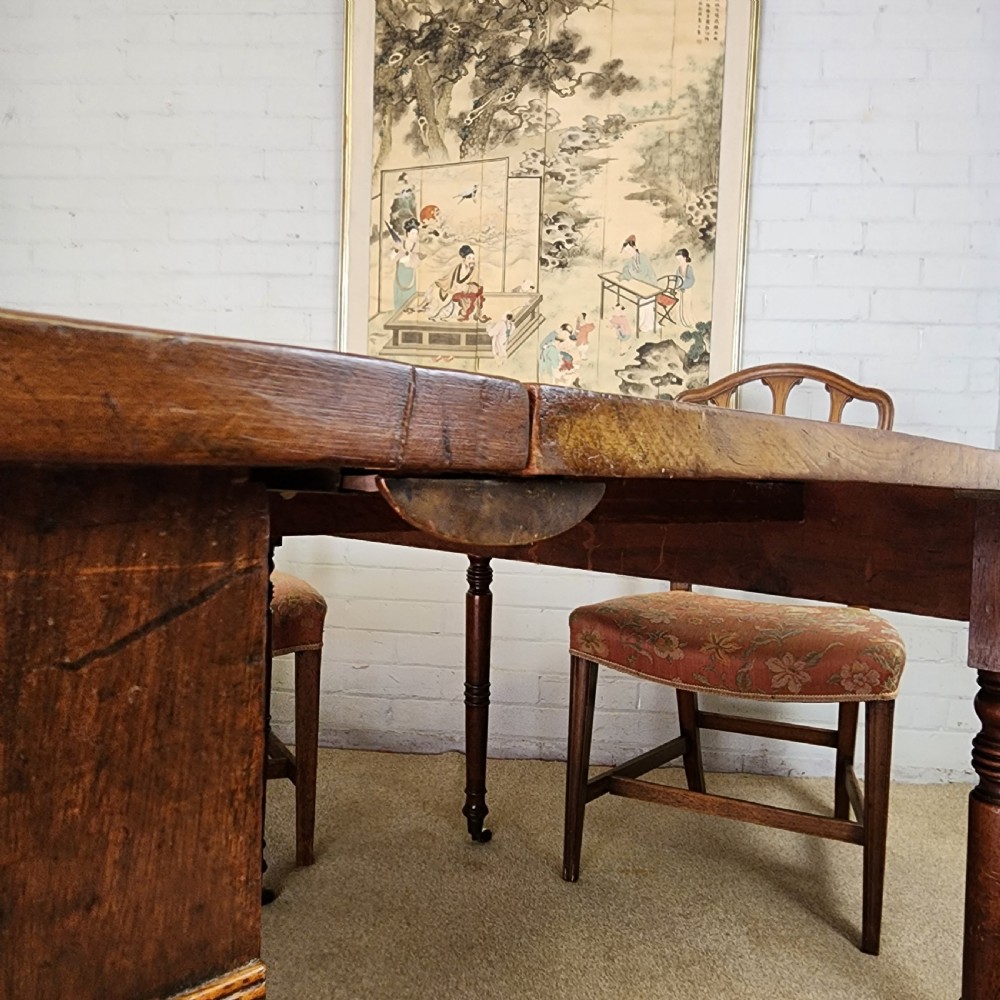A George IV mahogany extending dining table featuring rounded D-ends, a polished timber surface, and turned legs. View XIII