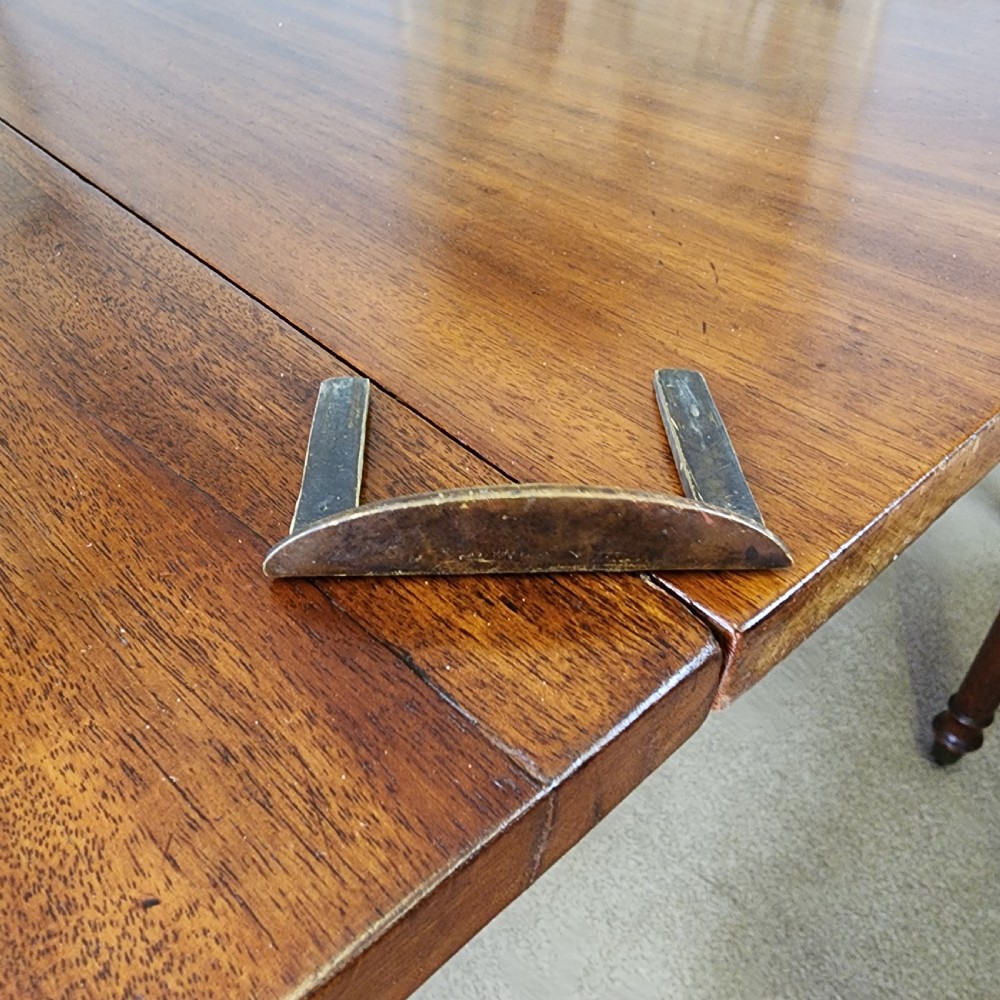 A George IV mahogany extending dining table featuring rounded D-ends, a polished timber surface, and turned legs. View XIV