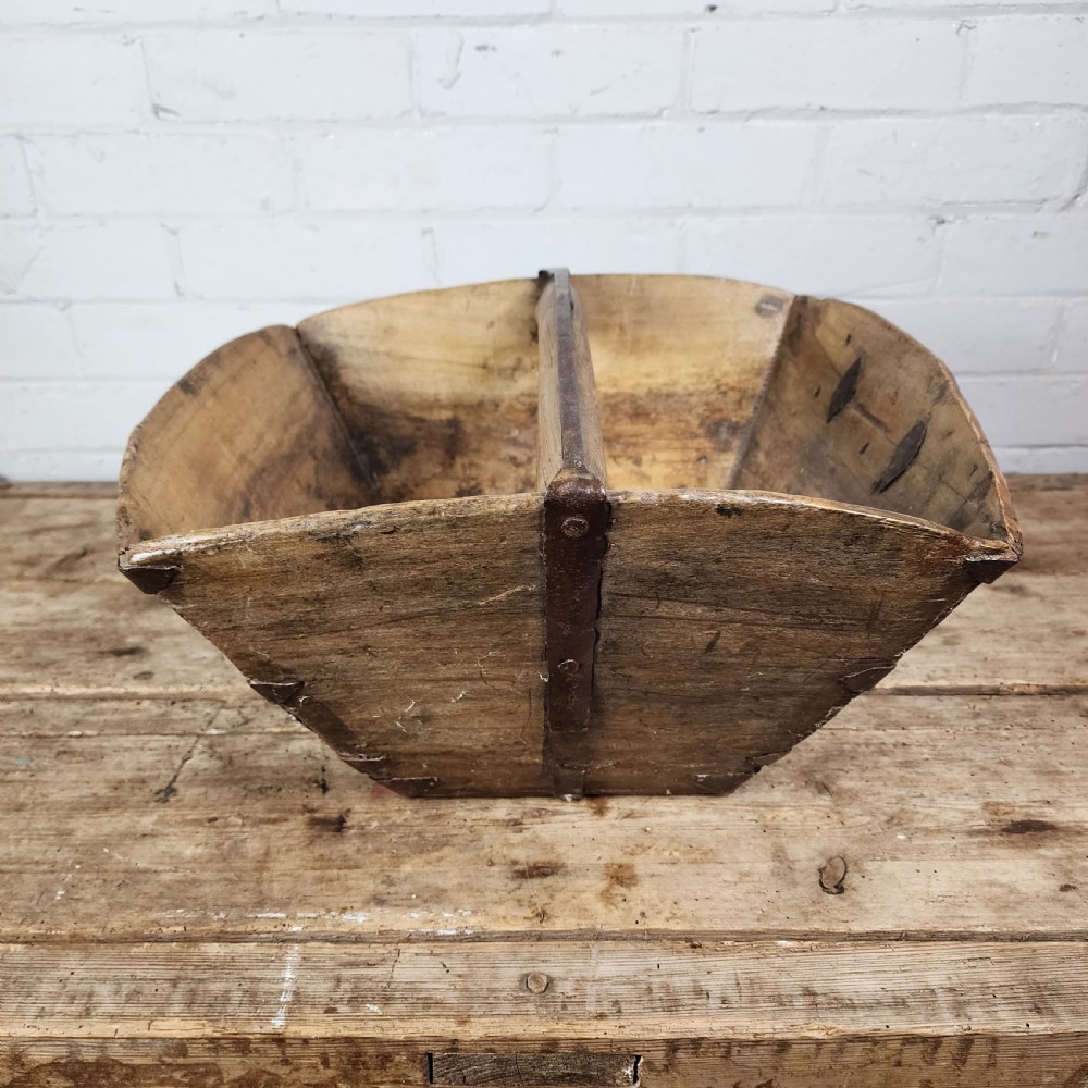 A nineteenth-century wooden garden trug featuring iron rim strapping, metal corner reinforcements, and a carved central carrying handle. View II