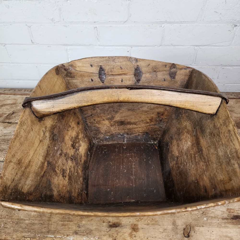 A nineteenth-century wooden garden trug featuring iron rim strapping, metal corner reinforcements, and a carved central carrying handle. View VI