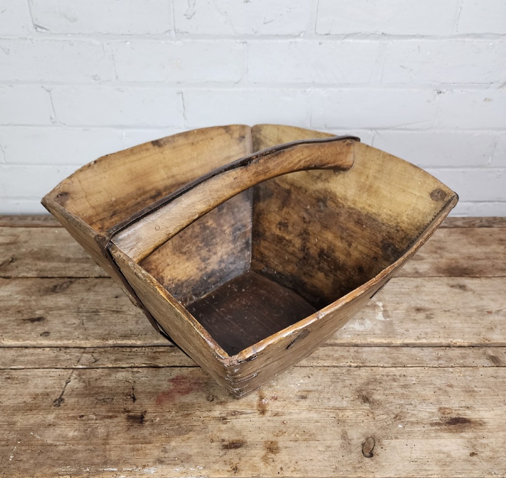 A nineteenth-century wooden garden trug featuring iron rim strapping, metal corner reinforcements, and a carved central carrying handle. View X