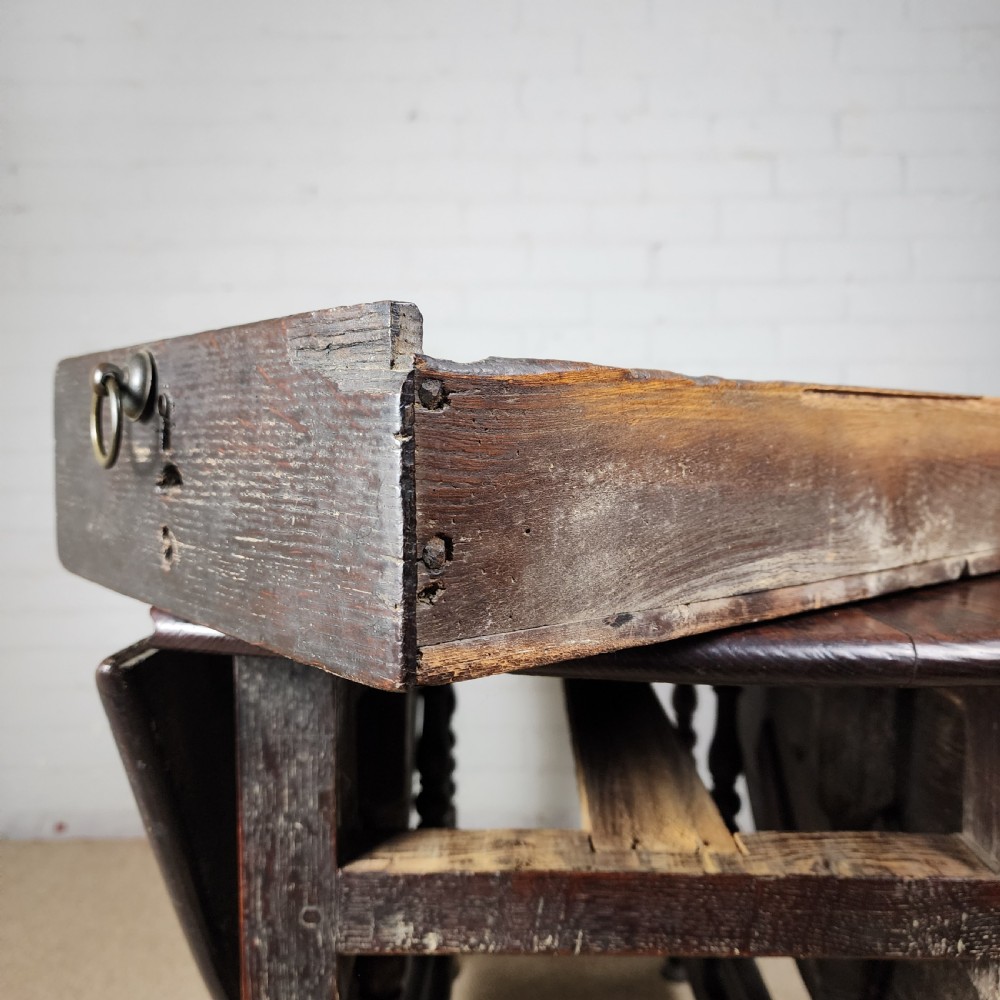 A late seventeenth-century dark oak gateleg dining table with turned legs and two drop leaves extended. View III
