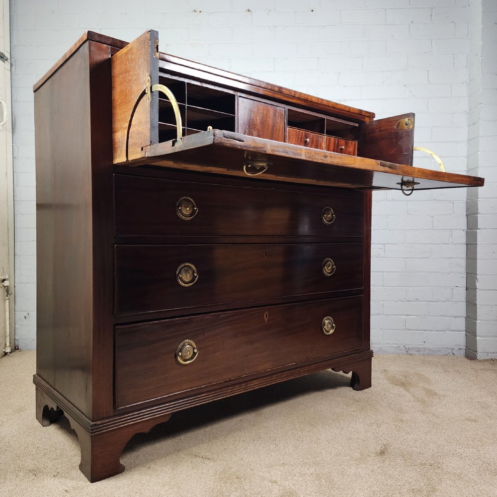 A Georgian mahogany secretaire chest of drawers featuring an open drop-front top section with small fitted drawers and pigeonholes above three lower drawers. View XII
