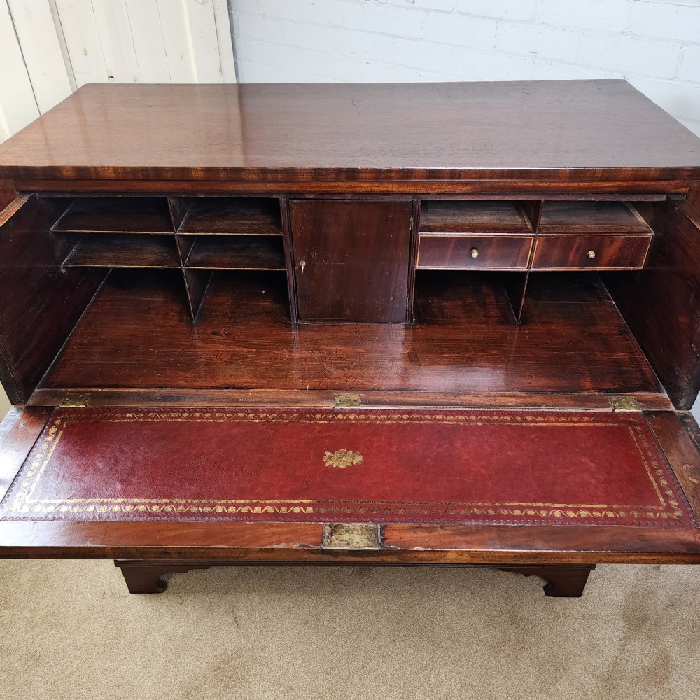 A Georgian mahogany secretaire chest of drawers featuring an open drop-front top section with small fitted drawers and pigeonholes above three lower drawers. View VI