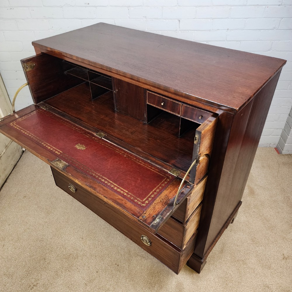 A Georgian mahogany secretaire chest of drawers featuring an open drop-front top section with small fitted drawers and pigeonholes above three lower drawers. View X