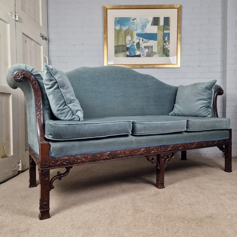 An early twentieth-century Chinese Chippendale style camelback sofa upholstered in light blue velvet with a hand-carved mahogany frame and fretwork legs.