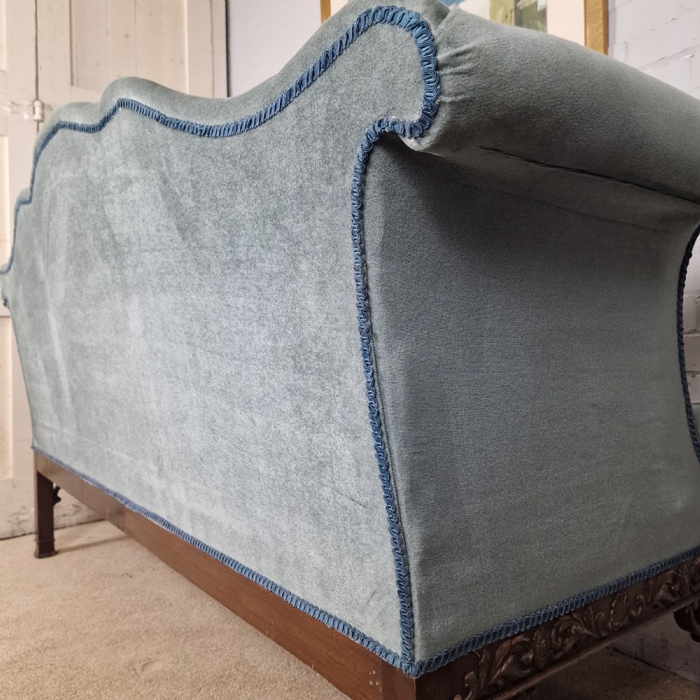 An early twentieth-century Chinese Chippendale style camelback sofa upholstered in light blue velvet with a hand-carved mahogany frame and fretwork legs. View X