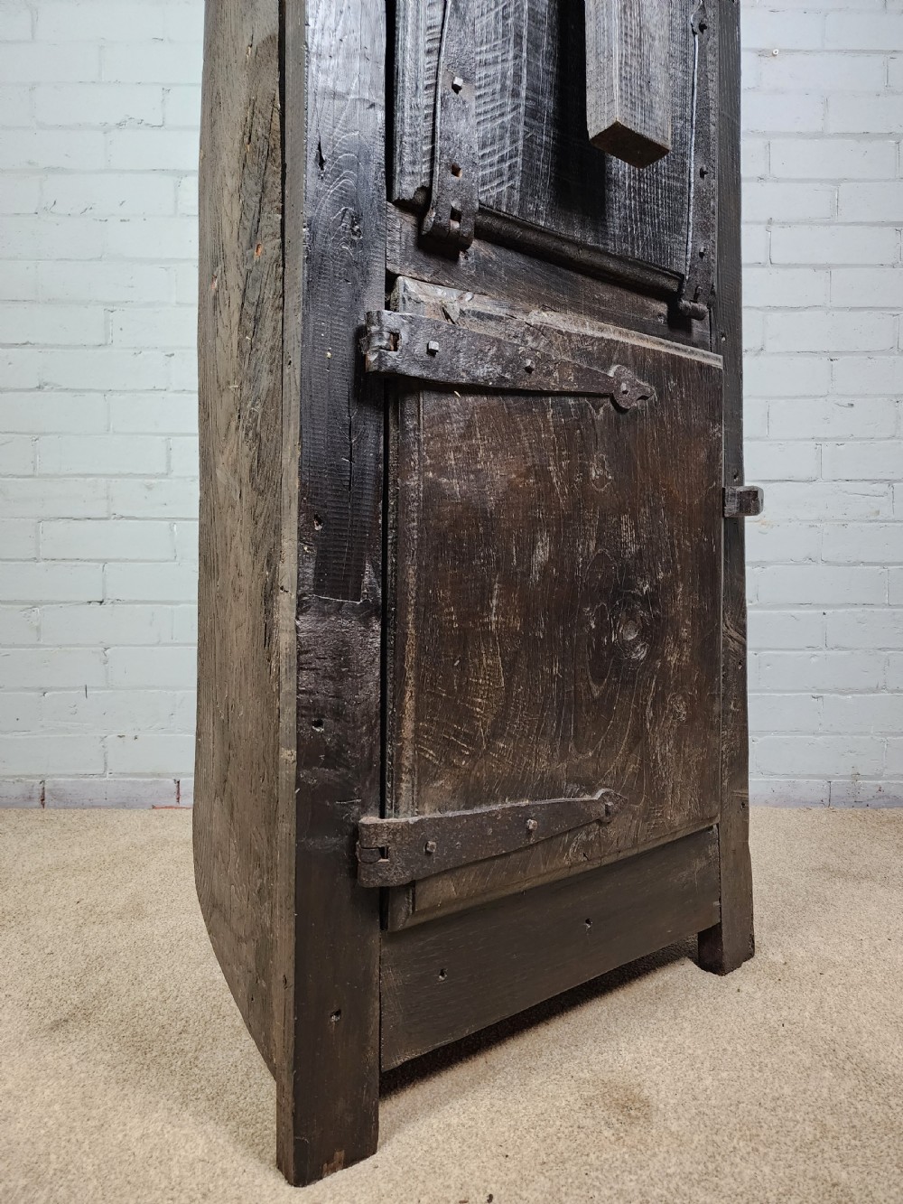 A tall dark oak metamorphic cupboard featuring open shelving, a lower cabinet, and an extended hinged table leaf supported by a angled leg. View II