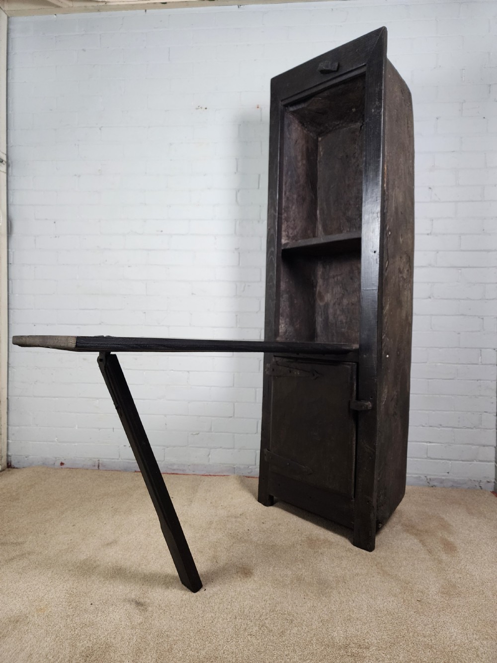 A tall dark oak metamorphic cupboard featuring open shelving, a lower cabinet, and an extended hinged table leaf supported by a angled leg. View X