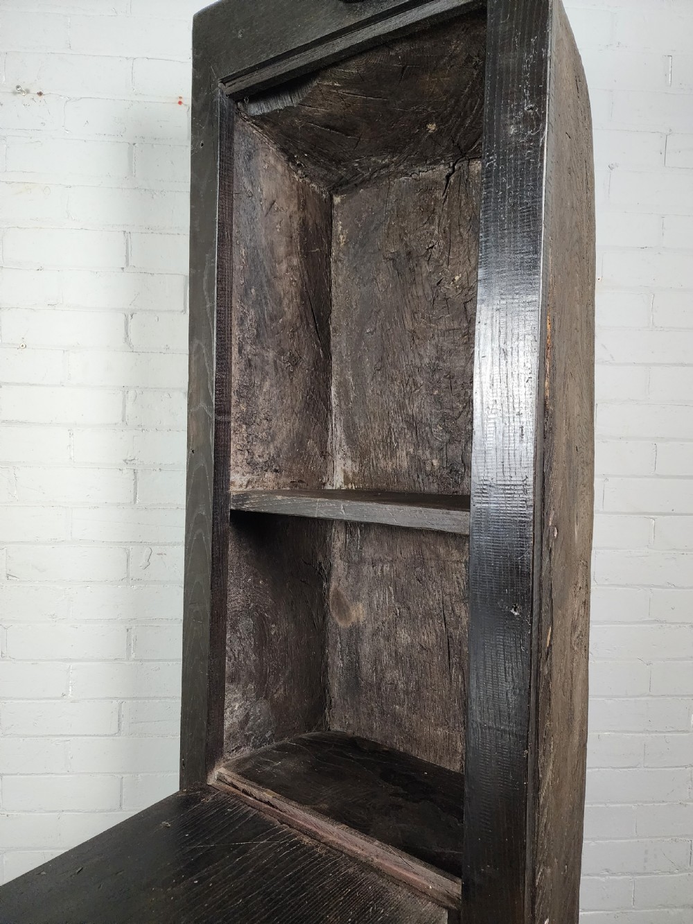 A tall dark oak metamorphic cupboard featuring open shelving, a lower cabinet, and an extended hinged table leaf supported by a angled leg. View XI