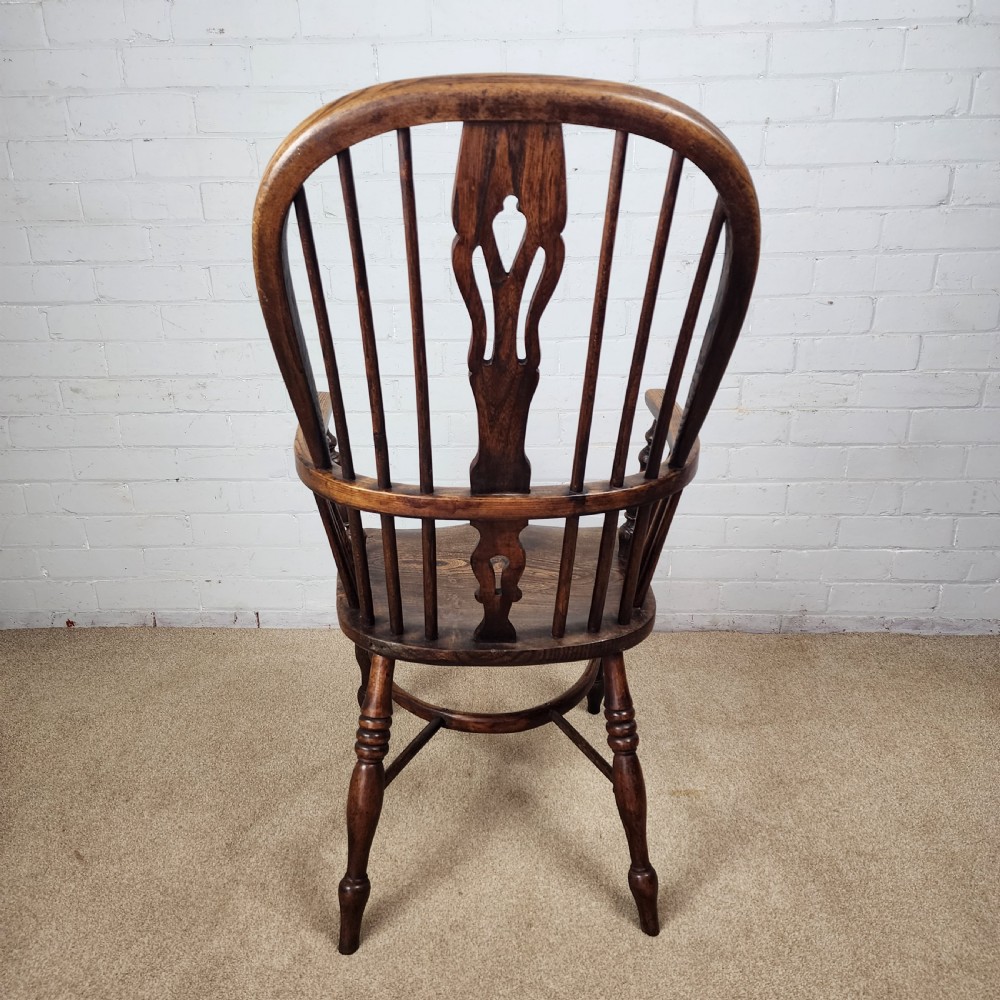 A 19th-century dark wood Windsor armchair featuring a high hoop back, pierced splat, turned legs, and a shaped elm seat. View VI
