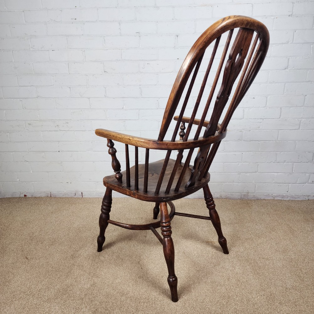 A 19th-century dark wood Windsor armchair featuring a high hoop back, pierced splat, turned legs, and a shaped elm seat. View VII