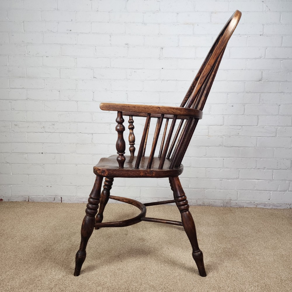 A 19th-century dark wood Windsor armchair featuring a high hoop back, pierced splat, turned legs, and a shaped elm seat. View VIII