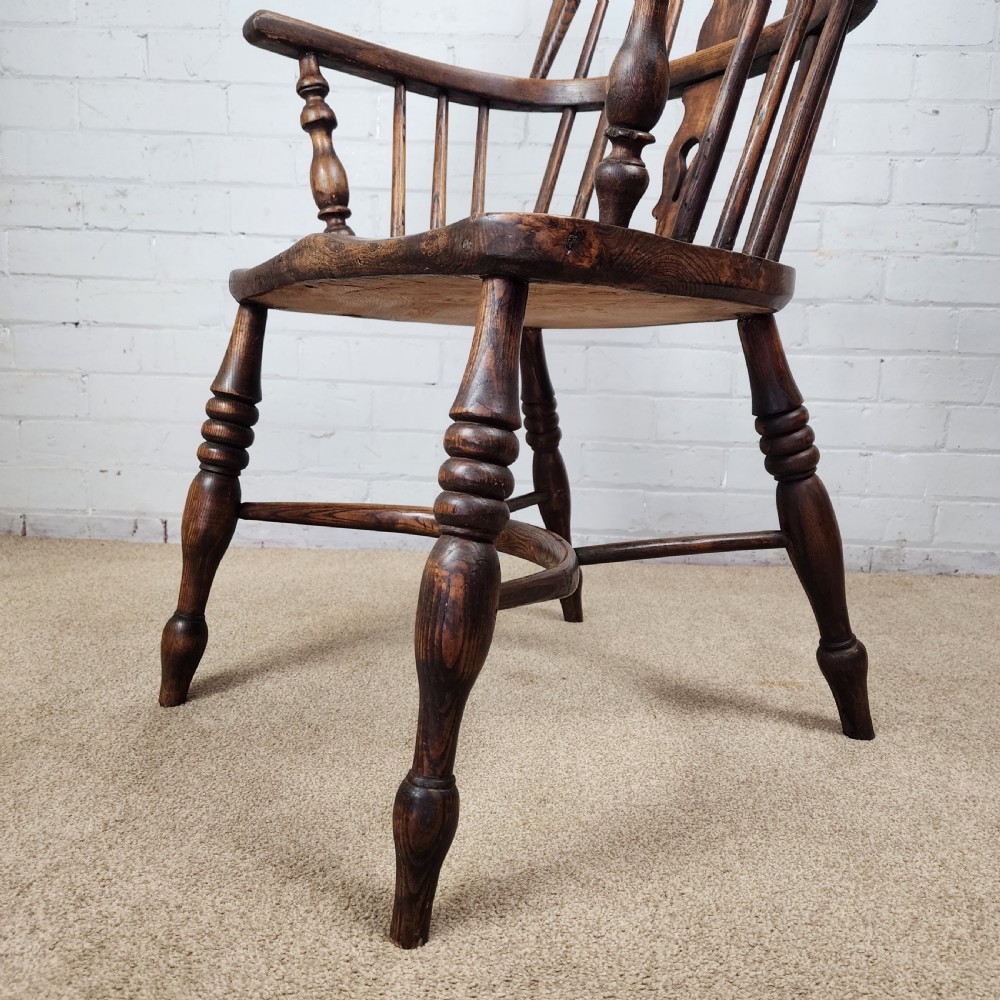 A 19th-century dark wood Windsor armchair featuring a high hoop back, pierced splat, turned legs, and a shaped elm seat. View IX