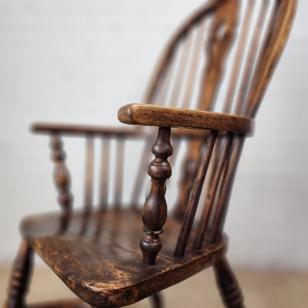 A 19th-century dark wood Windsor armchair featuring a high hoop back, pierced splat, turned legs, and a shaped elm seat. View X