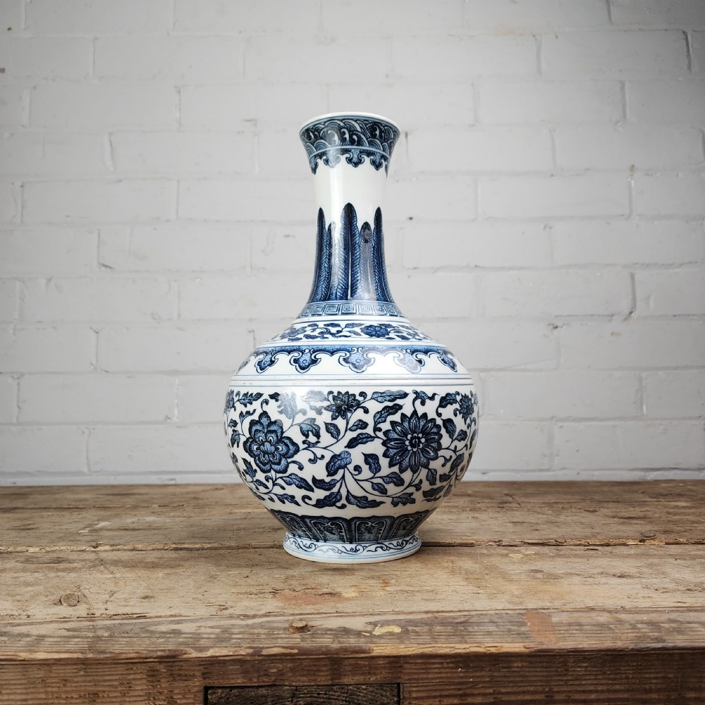 A Chinese blue and white porcelain bottle vase featuring hand-painted floral lotus scrolls and geometric leaf borders. View VII