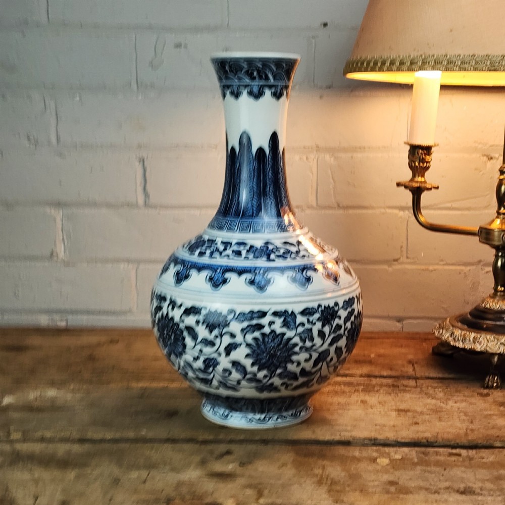 A Chinese blue and white porcelain bottle vase featuring hand-painted floral lotus scrolls and geometric leaf borders. View VI