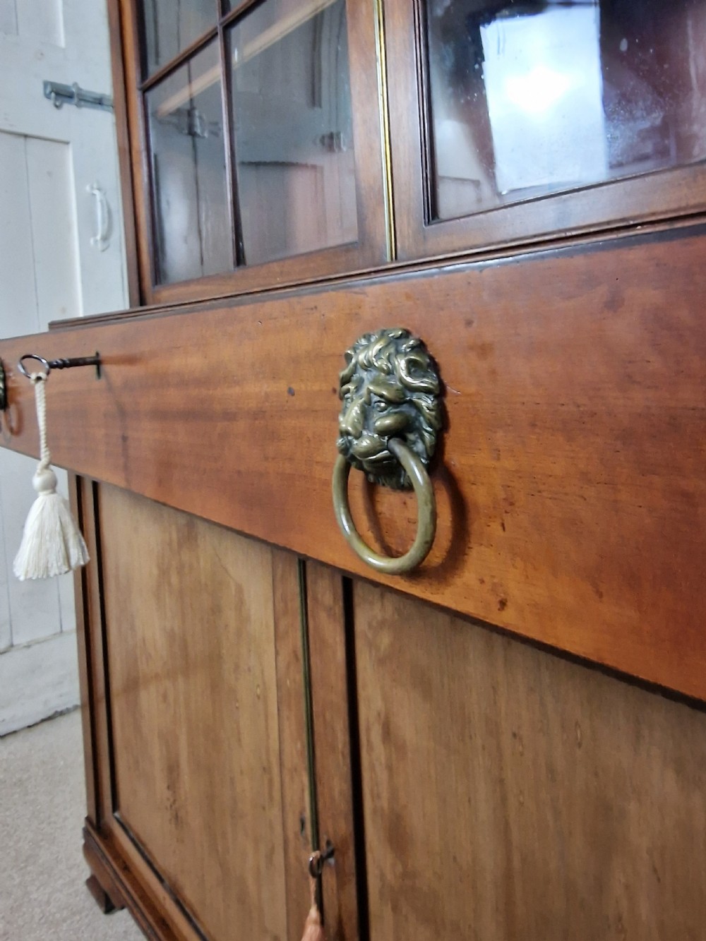 A George IV mahogany bookcase cupboard featuring glazed upper doors with Gothic arch glazing bars above a lower panelled cupboard. View III