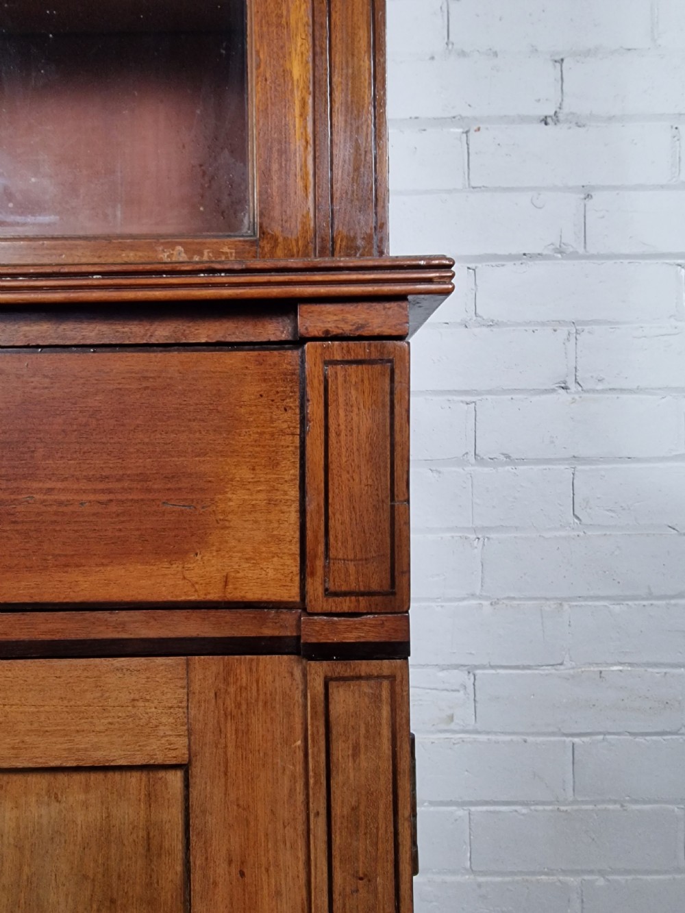 A George IV mahogany bookcase cupboard featuring glazed upper doors with Gothic arch glazing bars above a lower panelled cupboard. View IX